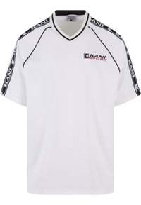 Balta trumpa rankovė t-shirt su V iškirpte, turinti juodus akcentus, logotipą priekyje ir kontrastingas petnešas.