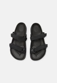 Sandales noires à bout ouvert avec deux larges sangles en tissu réglables sur chaque pied, semelle intérieure texturée et semelle profilée sur fond blanc.
