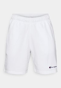 White cotton shorts with an elastic waistband and a straight cut. Features a small blue and red "Champion" logo on the lower left.