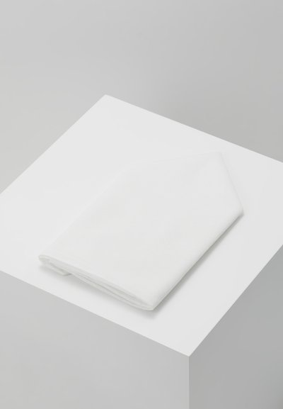 White cotton napkin folded in a triangular shape, resting on a white pedestal, with smooth texture and clean edges.
