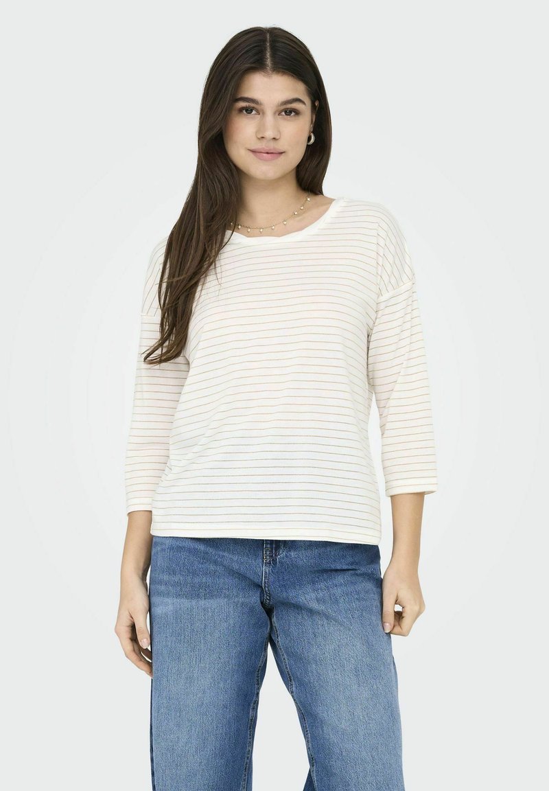 Licht crèmekleurig shirt met lange mouwen en subtiele horizontale strepen in pastelkleuren. Ontspannen pasvorm met een ronde hals, gecombineerd met blauwe denim jeans.