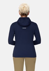 Navy blue insulated jacket featuring a hood, textured fabric with horizontal stripes, and a white logo on the upper back.