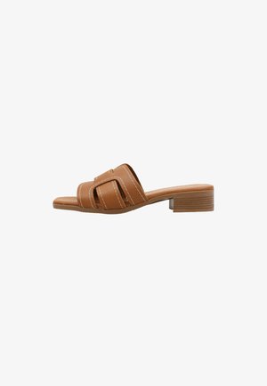 Sandalia tipo slide de cuero marrón con punta cuadrada, tiras decorativas recortadas y un tacón bajo de bloque apilado.