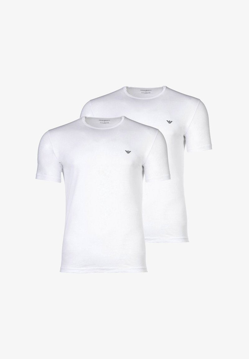 Deux t-shirts blancs unis manches courtes à col rond avec un petit logo aigle noir sur le côté gauche de la poitrine.