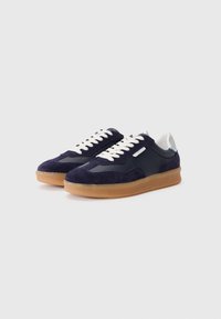 Navy ruskinds sneakers med gummisål, hvide snørebånd og en kontrasterende grå syntetisk panel på siden. Rounded toe design.
