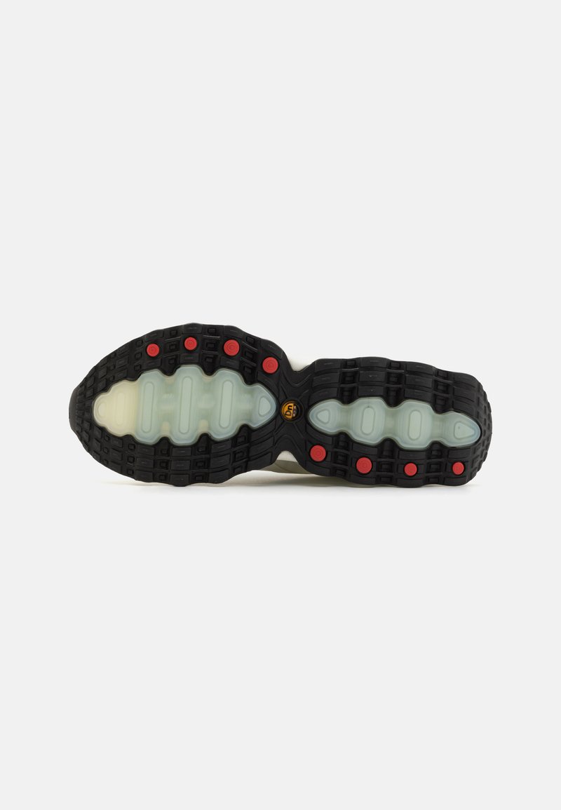Schuhsohle mit schwarzem Gummi-Rand und roten Akzenten, einer durchsichtigen Zwischensohle und einem strukturierten Profilmuster für Traktion.