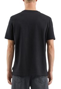 Czarny bawełniany T-shirt z krótkimi rękawami i okrągłym dekoltem. Tkanina jest gładka, a krój prosty, z minimalnym detalem brandingowym.