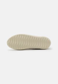 Beżowa podeszwa do sneakersów z falistym wzorem tekstury, zaprojektowana z myślą o przyczepności i elastyczności, z zaokrąglonymi krawędziami i gładkim wykończeniem.