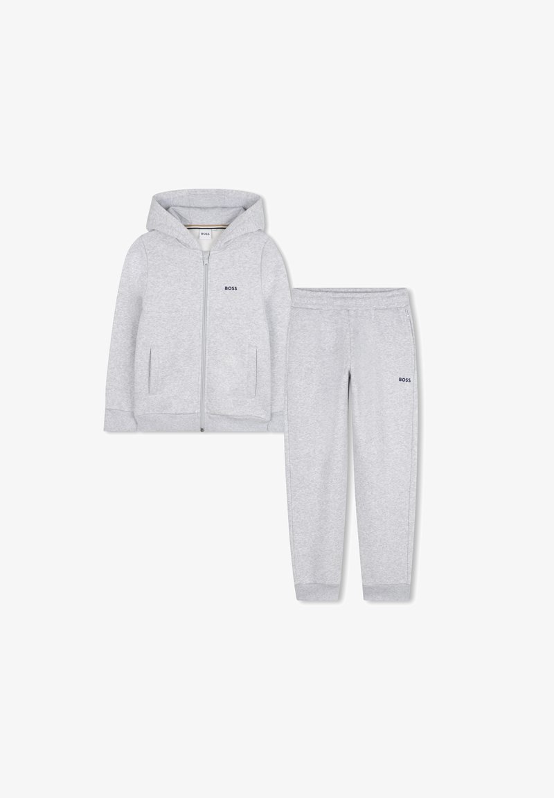 Sweatshirt cinza com capuz, fecho à frente e dois bolsos, combinado com calças de sweat iguais, com um cós elástico. Ambos os itens têm um logótipo.