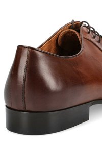 Brązowe skórzane buty formalne z okrągłym noskiem, gładką fakturą, czarną gumową podeszwą i minimalnym przeszyciem wzdłuż szwów.