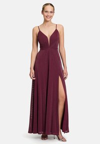 Robe bordeaux avec un décolleté en V profond, des fines bretelles et une fente à l'avant. Fabriquée en tissu texturé avec un léger éclat, présentant un corsage ajusté et une jupe fluide.