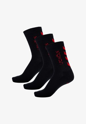 Sorte sokker med ribbede manchetter, med røde accenter og tekst. Blød tekstur med sømløs tådesign. Pakke med tre par.