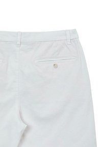 Pantalons en coton blancs présentant une poche arrière avec un bouton et une finition lisse et texturée. Taille ajustée avec passants de ceinture.