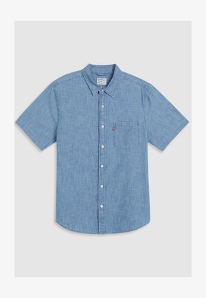 Chemise en denim à manches courtes de couleur bleu clair, avec une poche avant, un col et un ourlet légèrement arrondi.