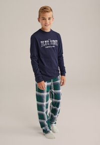 Jūras spēku garo piedurkņu krekls ar tekstu "BLUE RIDGE CAMPUS CLASSICS", kombinēts ar zaļiem un baltiem uzrakstiem dienas džemperiem. Mīksta materiāla, ikdienišķs piegriezums.