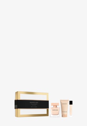 Set de regalo de fragancia Narciso de lujo con caja dorada y negra, botella de perfume, loción corporal y spray de tamaño viaje sobre fondo blanco.