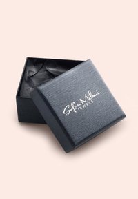 Svart texturerad smyckeslåda med lock, prydd med en vit logotyp "Sofia Milani Jewels." Insidan är fodrad med svart silkespapper.