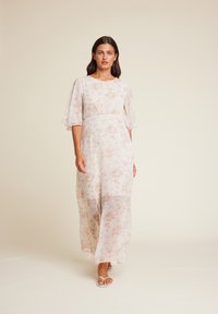 Blomstre maxi-kjole i lett, gjennomsiktig stoff, med korte flommede ermer, en tettsittende midje og pastellfargede rosa og lilla blomster mønstre.