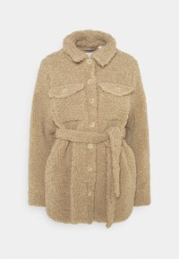 Beige sako z sherpy na knoflíky s límcem, dvěma náprsními kapsami na knoflík a odpovídajícím páskem z látky uvázaným v pase.