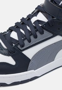 Höga sneakers i en blandning av marinblått, grått och vitt läder. Har texturerade läderdetaljer, platta marinblå snören och vadderad krage.