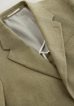 Beżowa lniana marynarka z wyciętym klapą i widoczną wewnętrzną podszewką z satyny z subtelnym kwiatowym wzorem.