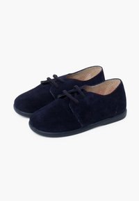 Scarpe scamosciate blu navy con punta arrotondata, allacciatura frontale e suola piatta in gomma. Texture morbida e design minimalista.