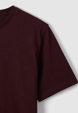 Bordo majica kratkih rukava od mekanog pamuka s okruglim izrezom i ravnim rubom. Glatka tekstura i minimalistički dizajn.