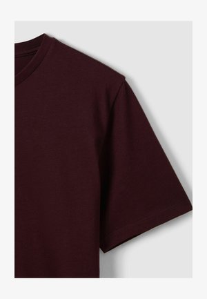 Burgundifarbenes Kurzarm-T-Shirt aus weicher Baumwolle mit Rundhalsausschnitt und sauberem Saum. Glatte Textur und minimalistisches Design.
