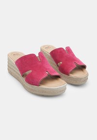 Sandales compensées en daim rose avec un design découpé et une plateforme texturée beige. Elles présentent une semelle intérieure beige lisse et de simples détails de couture.