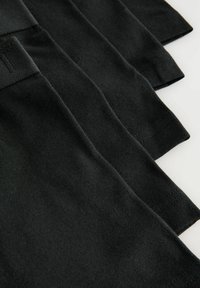 Tricouri din material negru, ușor, stivuite, cu mâneci scurte și un design simplu, având detalii de cusătură subtile.