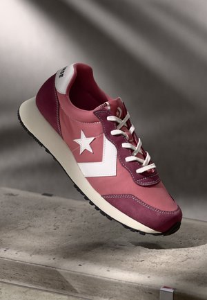 Baskets bordeaux et rose avec une étoile blanche et un logo triangulaire, dotées de suède texturé et de matériaux lisses, de lacets blancs et d'une semelle crème.