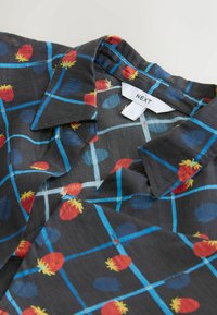 Cămașă neagră cu guler, având un model colorat de fructe în roșu, albastru și galben, accentuat de linii subțiri albastre în formă de grilă.