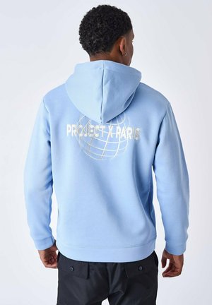 Hoodie bleu clair avec un grand logo brodé blanc "PROJECT X PARIS" et un design de globe au dos. Texture douce et coupe décontractée.