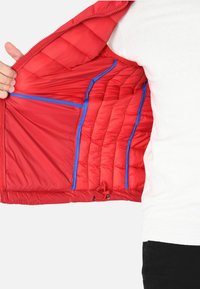 Giacca imbottita rossa con la parte anteriore aperta, che mostra accenti blu su tasche e fodera, caratterizzata da cuciture orizzontali e orlo regolabile.