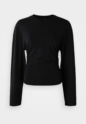 Top preto de manga longa feito de um tecido macio. Apresenta um decote redondo e detalhes franzidos na cintura. Textura suave, design ajustado.