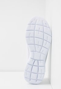 Sola di scarpa da ginnastica bianca con una superficie testurizzata e a trama per la trazione. Le scanalature flessibili e le sezioni rialzate migliorano la presa e il supporto.