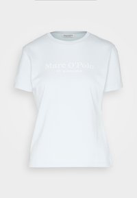 Camiseta de algodón azul claro de manga corta y cuello redondo, con texto blanco que dice "Marc O’Polo" y "EST. EN ESTOCOLMO" en la parte delantera.