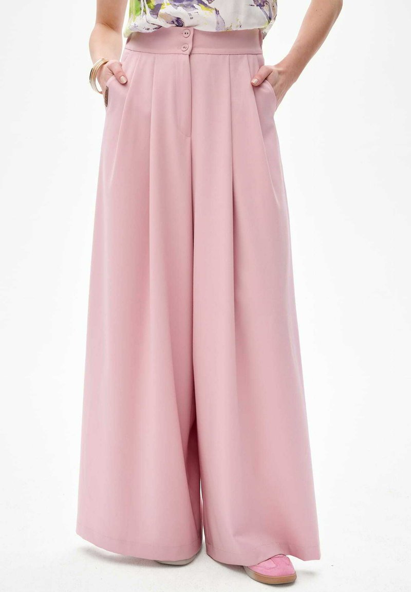 Lichtroze wijde broek met hoge taille, voorzien van twee zakken aan de voorkant en een dubbele knoopsluiting in de taille. Gladde stofstructuur.