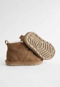 Braune Wildleder-Ankle Boots mit einem weichen Innenfutter, Gummisohle mit einem Profilmuster und einer Schlaufe für einfaches Anziehen.