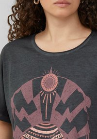 Grijze katoen t-shirt met een ronde hals. Bevat een grafisch ontwerp in het roze, dat geometrische vormen en een zonmotief uitbeeldt.