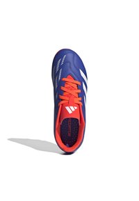 Bota de fútbol azul con acentos blancos y cordones rojos. Parte superior sintética suave con perforaciones para transpirabilidad. Diseño de puntera ligeramente redondeada.