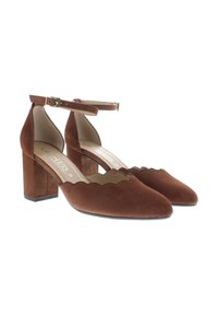Brown suede heeled shoes with a scalloped edge design, an ankle strap, and a chunky heel for stability. Smooth interior lining.
