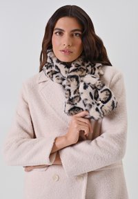 Écharpe en fausse fourrure avec un motif léopard, présentant des couleurs beige clair, noir et crème. Texture douce et bords arrondis.