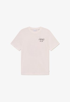 Világos bézs színű, rövid ujjú pamut póló. Az asztalon egy fekete nyomott logó található a bal mellen, sima tapintású és klasszikus fazonú.