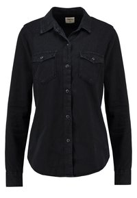 Chemise noire à manches longues, boutonnée, avec col, deux poches à rabat sur la poitrine et petits embellissements en clous sur les panneaux d'épaules.