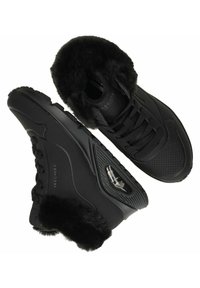 Schwarze Sneakers mit einer strukturierten, perforierten Oberseite, flauschiger Knöchelstütze und kontrastierenden glatten Akzenten. Verfügt über sichtbare Schnürsenkel und eine dicke Gummisohle.