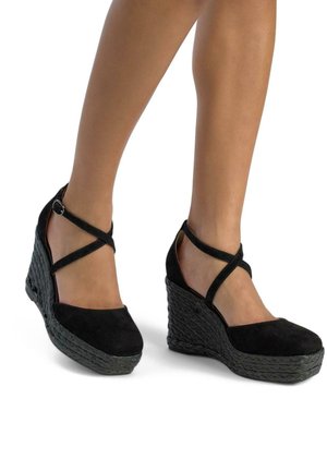 Scarpe con zeppa nere in suede con cinturini incrociati alla caviglia, suola intrecciata testurizzata e design a punta arrotondata.