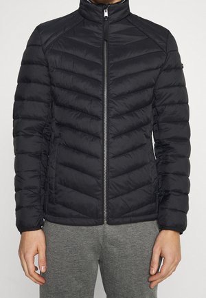 Sort pufferjakke med chevron-quilting, høj krave og lynlås foran. Blødt, let materiale med elastiske manchetter, minimalistisk design.