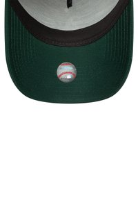 Gorra de béisbol verde con visera negra. Presenta una pegatina circular en la parte inferior con costuras rojas que parecen un béisbol.