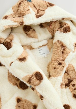 Bata de felpa con capucha en color crema con un patrón de osos marrones, que presenta una textura suave, material mullido y una etiqueta frontal que dice "NEXT time to dream".